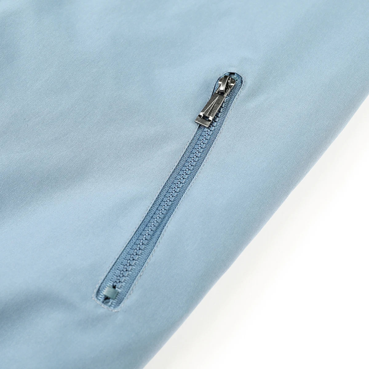 Light blue shirt with a zipper detail on a light gray background