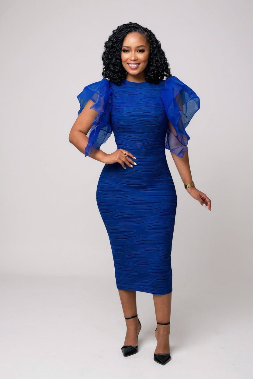 Woman wearing a blue dress with sheer sleeves against a white background