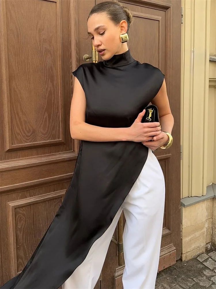 Woman in a black and white outfit standing in front of a wooden door.