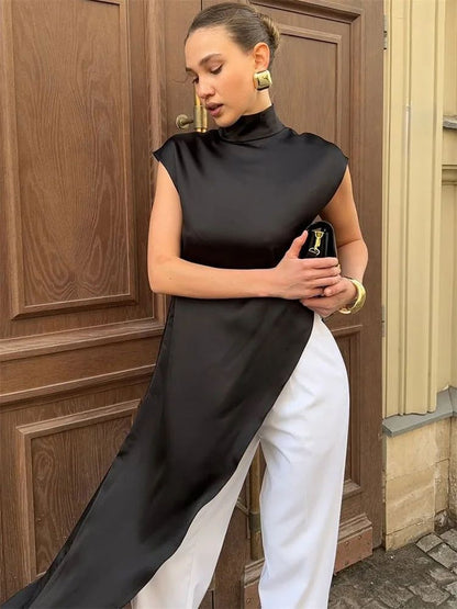 Woman in a black and white outfit standing in front of a wooden door.