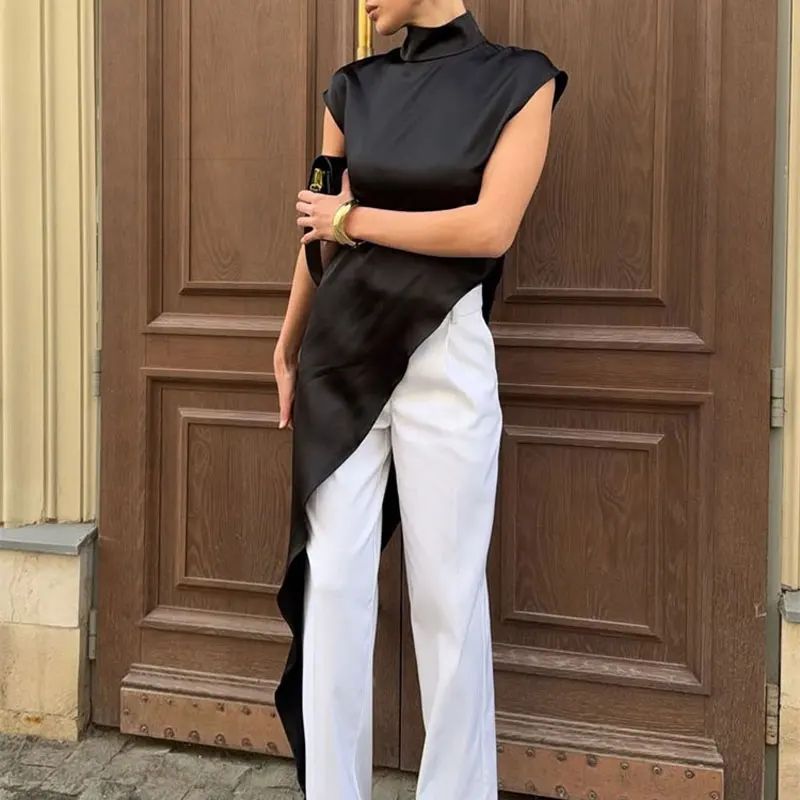 Person wearing a black and white outfit standing in front of a wooden door.