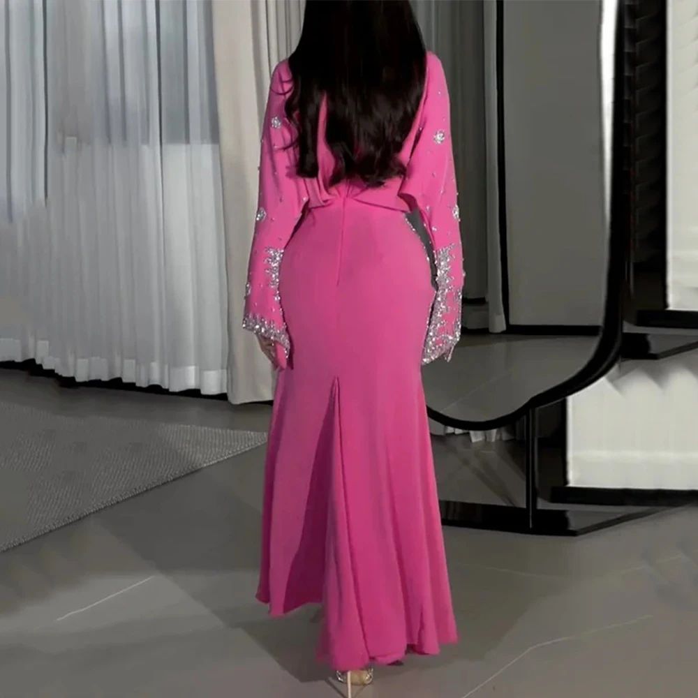 Person wearing a pink dress with embellishments in an indoor setting