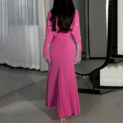Person wearing a pink dress with embellishments in an indoor setting