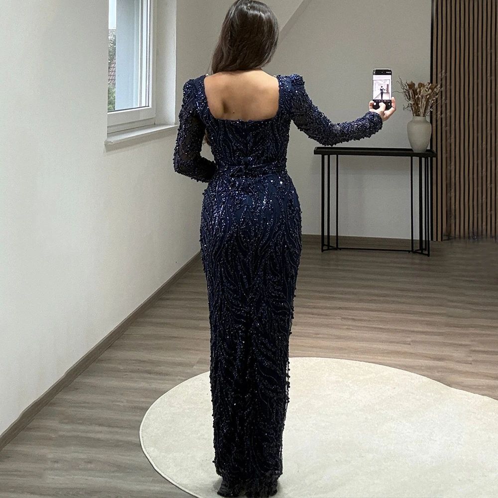 Person wearing a sparkly blue jumpsuit taking a photo of themselves in a room.