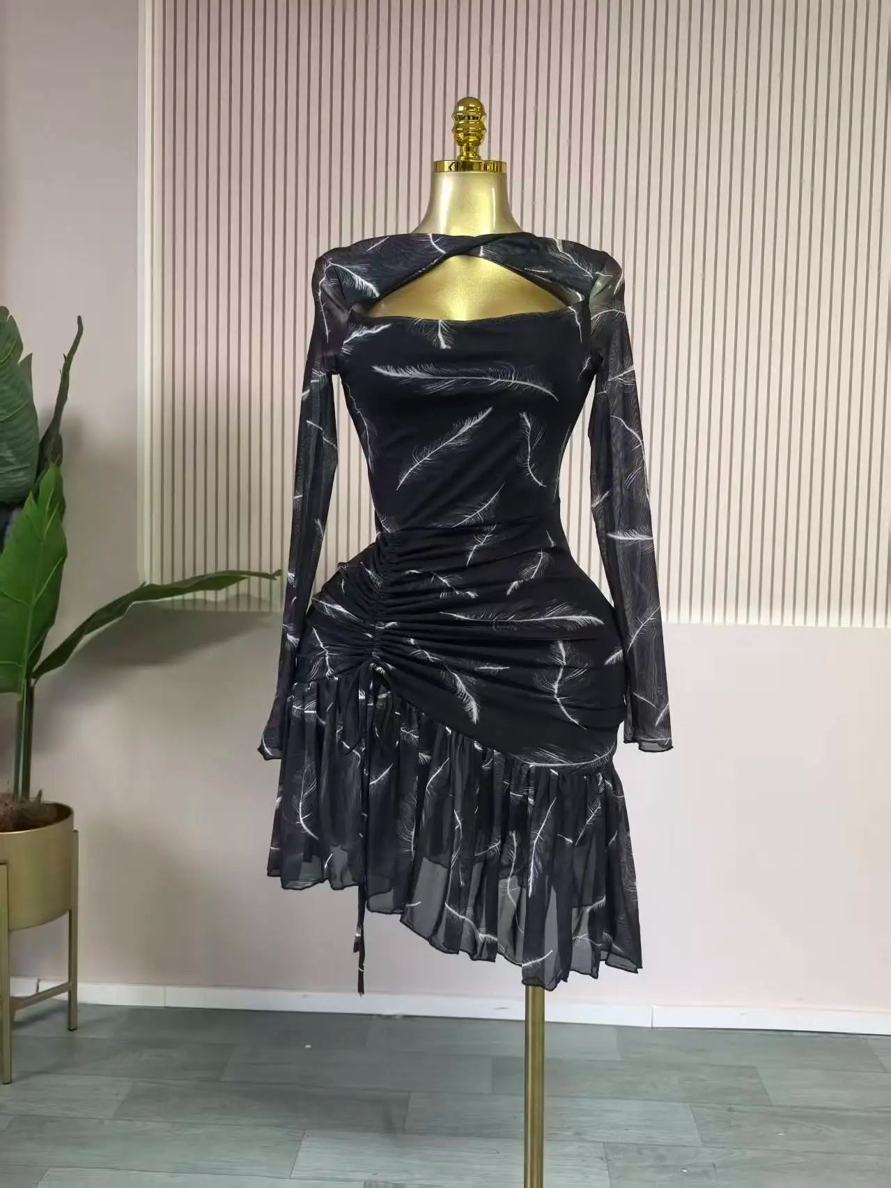Black patterned dress on a mannequin against a neutral background