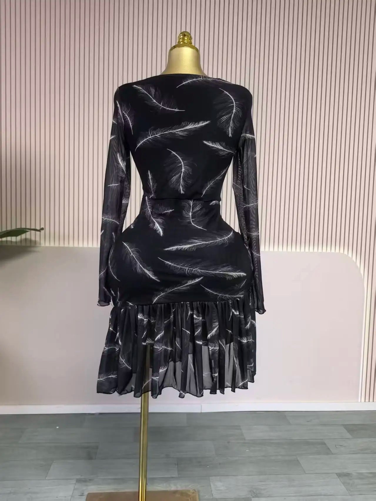 Black textured dress on a mannequin against a neutral background