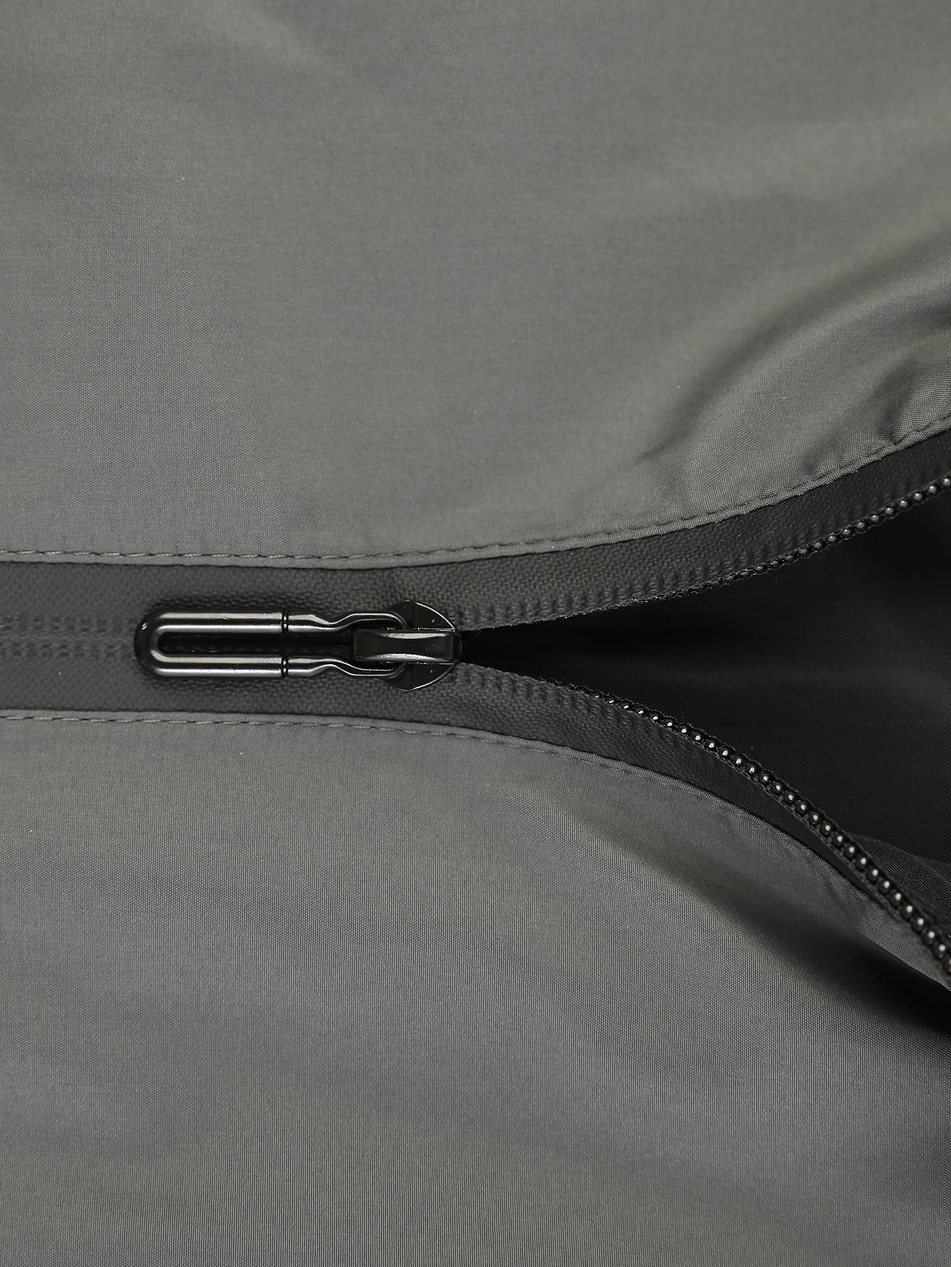 Close-up of a zipper on a gray fabric surface