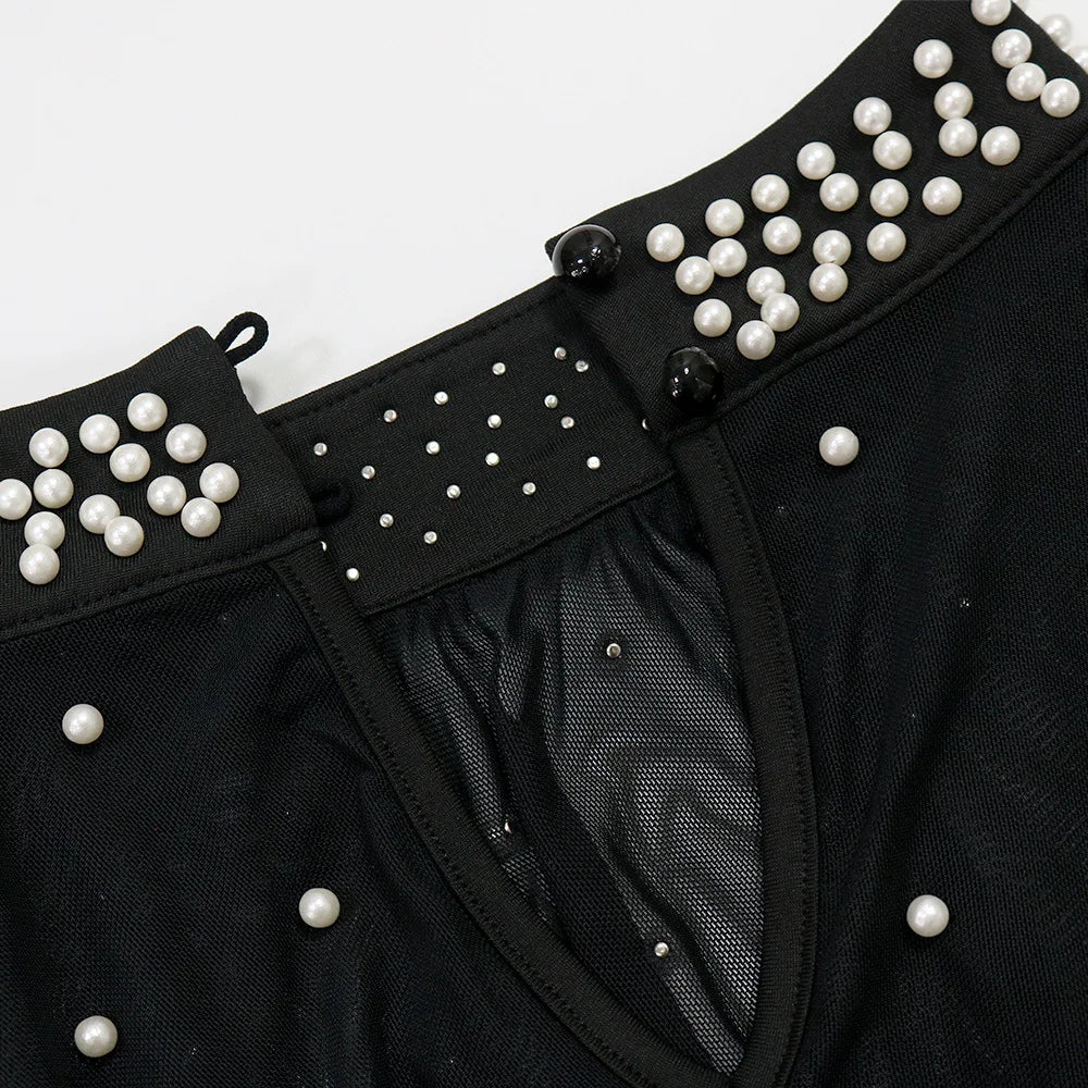 Black garment with pearl embellishments on a white background