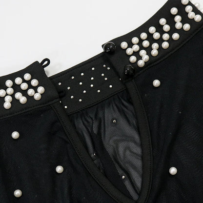 Black garment with pearl embellishments on a white background