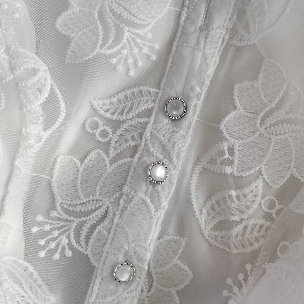 Close-up of a lace fabric with floral patterns and buttons.