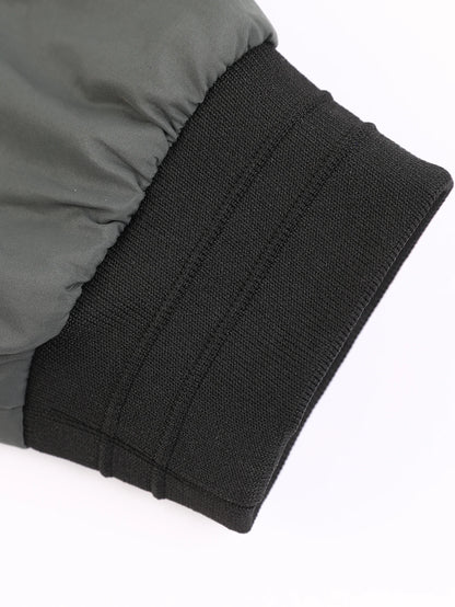 Close-up of a gray jacket with black ribbed cuffs on a white background