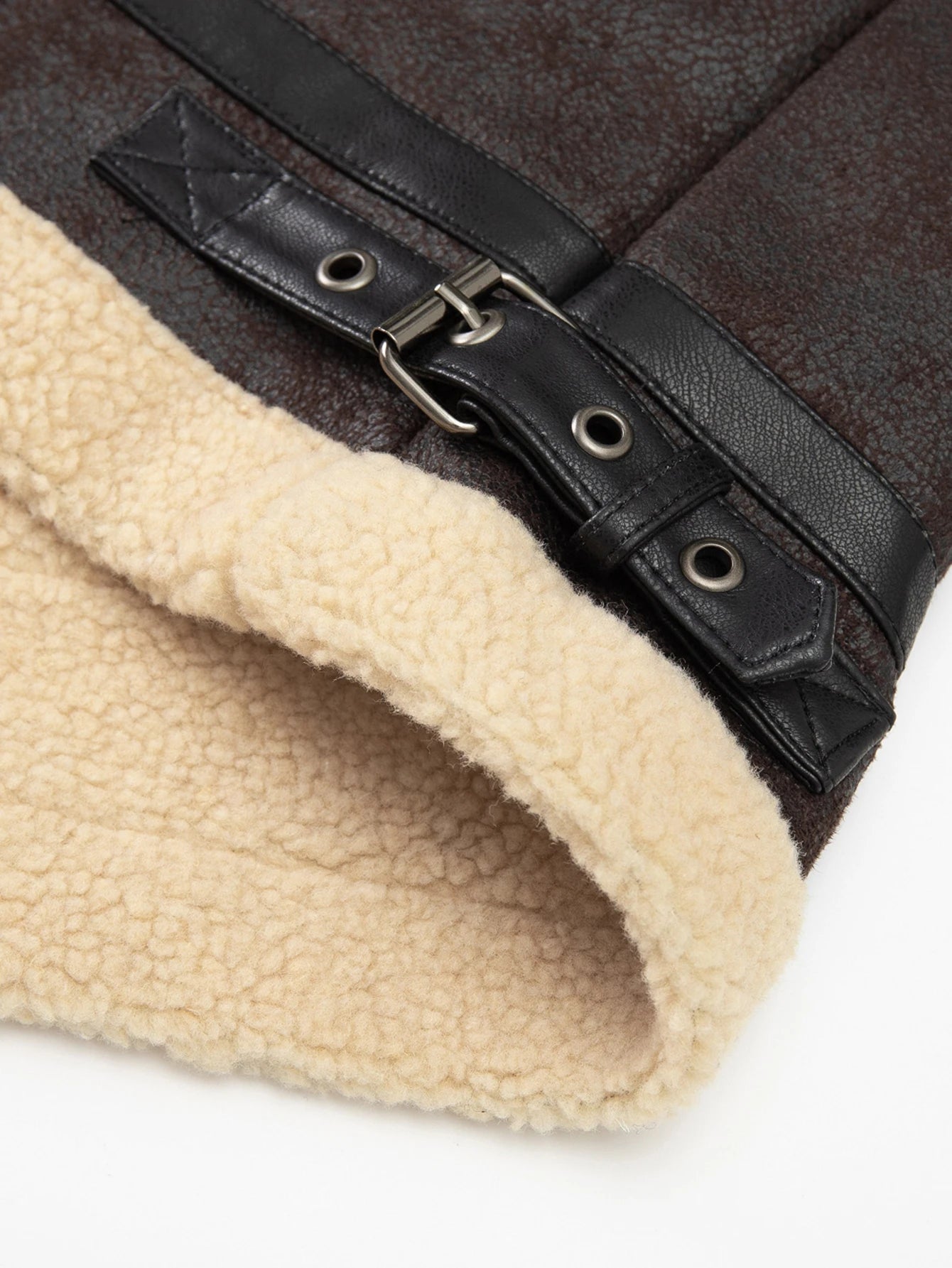 Close-up of a brown leather belt with a buckle on a beige fabric background