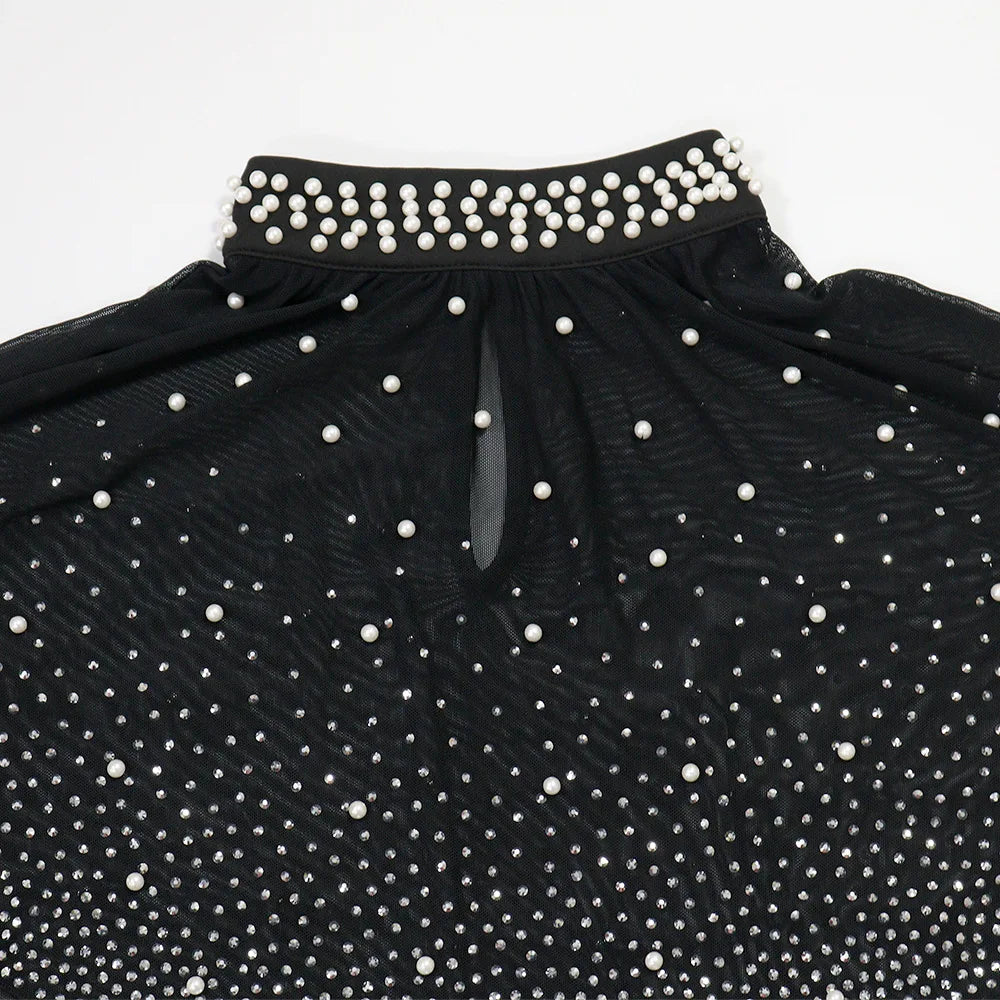 Black dress with white pearl embellishments on a white background