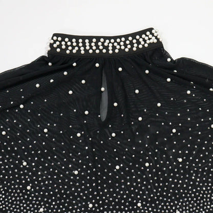 Black dress with white pearl embellishments on a white background