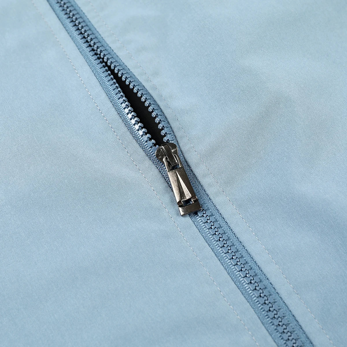 Close-up of a zipper on a light blue fabric background
