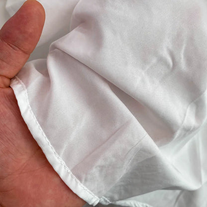 Close-up of a hand holding a white fabric item