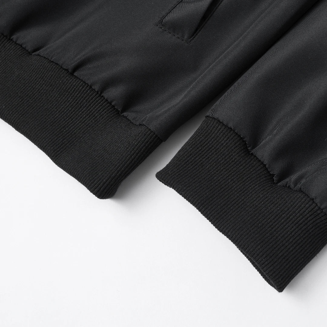 Close-up of a black jacket with ribbed cuffs on a white background